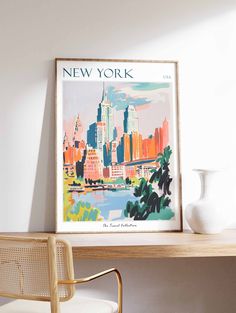 a framed new york city poster on a wall next to a chair and table with a vase