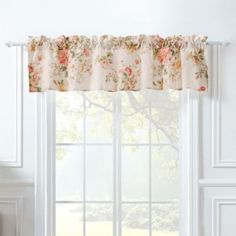 a window with a flowered valance hanging from it's side