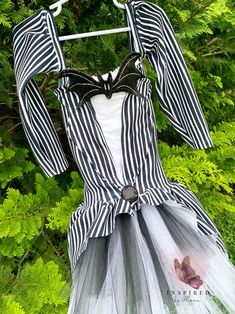 a black and white striped dress hanging from a tree