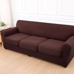 a brown couch sitting on top of a hard wood floor next to a wooden table