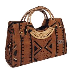 Introducing the Nasika Tote, a stunning handbag crafted from rich mudcloth. This traditional Malian fabric is renowned for its unique texture and cultural significance, making each bag a wearable piece of art. The intricate patterns and earthy tones of the mudcloth create a sophisticated look that's both elegant and eye-catching. With its spacious interior, sturdy cane handles, and inner pocket, this bag is as functional as it is beautiful. Every purchase supports women from low-income weaving communities in Accra, Ghana, empowering them to thrive. Make a statement and celebrate cultural heritage with the Nasika Tote Details: Cane Handle Length 15” x Height 10.5” x Depth 6” Material - Handmade mudcloth Top Zipper closure, Inner side pocket Produced in Ghana Processing and delivery:Please a Statement Bags, Soft Accessories, Accra Ghana, Cane Handles, Concept Ideas, Bag Obsession, Statement Bag, Low Income, Boho Designs