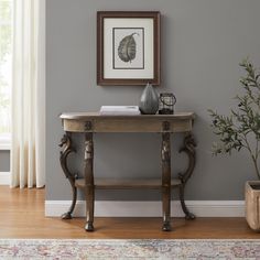 a wooden table sitting next to a potted plant on top of a hard wood floor