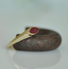 "This is a special red Ruby wedding ring.  A unique fine hand made gold ring. Beautiful red marquise Ruby sets on the center of 14k solid gold ring. The Ruby sets in an upper central bezel that made a specially for this stone. The angle of the bezel go all around the ring from side to side. This fine jewelry ring will make you feel pretty and special. Dimensions: *  14k gold ring * Marquise Ruby: 8m\"m * 4 m\"m  For other rings in my shop you can look here: https://www.etsy.com/il-en/shop/malkaravinajewelry?section_id=13724109&ref=shopsection_leftnav_2   A similar ring of main in \"lucky magazine\"  http://www.luckymag.com/shopping/2013/06/etsy-engagement-rings_slideshow_item16_17 My jewelry shop: https://www.etsy.com/il-en/shop/malkaravinajewelry?ref=seller-platform-mcnav" Red Marquise 14k Gold Jewelry, Unique Yellow Gold Ruby Promise Ring, Red 14k Gold Marquise Ring, Red Ruby Ring With Bezel Setting For Promise, Red Marquise 14k Gold Ring, Red Ruby Promise Ring With Bezel Setting, Formal Red Stackable Rings In 14k Gold, Red Ruby Ring In 14k Gold For Promise, Red Ruby Ring In 14k Gold With Bezel Setting