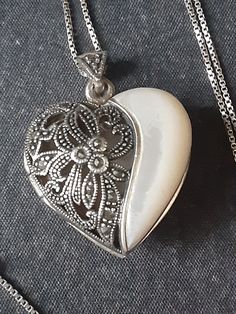 925 Sterling 24 inch box chain and heart shape locket.  Pendant is 1 x 1 inch.   Vintage with MOP, diamond accents and scroll design on front, shinny back side.  Holds single picture.  Spring ring clasp. Formal White Double Heart Necklace, Heart-shaped Filigree Jewelry Keepsake, Formal White Sterling Silver Heart Necklace, Elegant Silver Heart Locket Necklace, Silver Heart Cut Keepsake Jewelry, Vintage White Heart Pendant Jewelry, Silver Heart Cut Jewelry For Keepsake, White Hallmarked Jewelry For Valentine's Day, White Engraved Jewelry For Valentine's Day