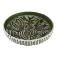 a green and white bowl sitting on top of a table