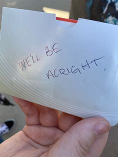 a person holding up a piece of paper with writing on it that says, we'll be alright