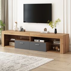 a living room with a large flat screen tv mounted on the wall and two drawers below it