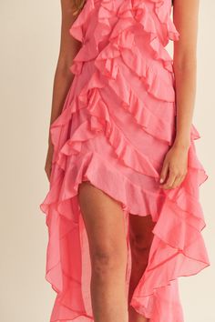 a woman wearing a pink dress with ruffles