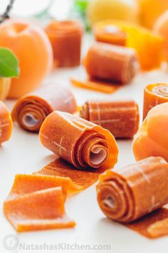 several orange candies on a white surface with one cut in half and the other rolled up