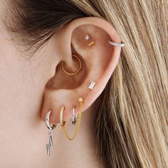 a woman's ear with three different piercings