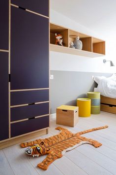 an animal rug is laying on the floor in front of a bed and cupboards