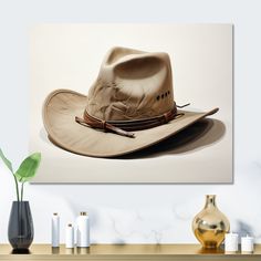 a cowboy hat on a table next to a vase