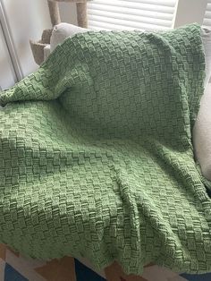 a green blanket sitting on top of a couch