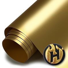 a gold wallpaper with the letter h on it's side and a round sticker in front