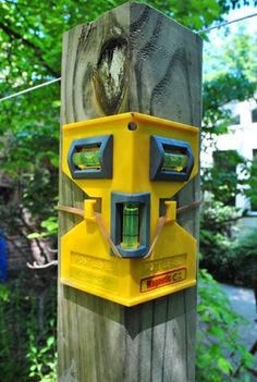 a yellow and blue device attached to a wooden pole