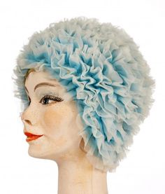 a mannequin head wearing a light blue hat with ruffles on it