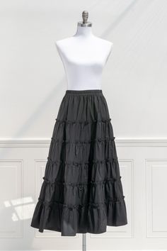 An elegant-yet-versatile skirt perfect for mixing-and-matching, the 100% cotton Antoinette skirt in black features tiers accented with ruffles, a comfortable elastic waistline, and flowy silhouette made for twirling! . Details: S: Waist 26"-32", Length 35" M: Waist 28"-34", Length 35.5" L: Waist 30"-36", Length 36" Elastic Waistline Material: 100% Cotton Unlined Care: Hand Wash Cold / Hang Dry Imported Ships in 1 to 2 Business Days Free US Shipping on Orders over $100 Cotton Tiered Skirt With Elastic Waistband, Black Cotton Maxi Skirt For Summer, Summer Black Cotton Maxi Skirt, Spring Maxi Skirt With Ruffles, Black Cotton Maxi Skirt With Elastic Waistband, Cotton Tiered Voluminous Skirt, Voluminous Tiered Maxi Skirt With Ruffles, Ruffled Cotton Maxi Skirt, Cotton Flowy Skirt With Layered Hem