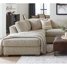 a living room scene with focus on the couch and chair, coffee table and ottoman