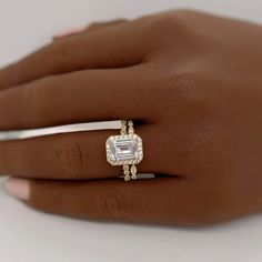 a woman's hand with a diamond ring on top of her finger and an engagement band