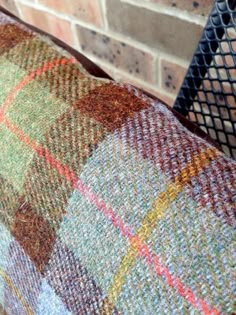 a close up of a pillow on a chair near a brick wall and fire place