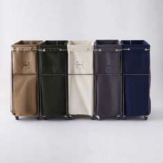 six different colored bags with handles on each side and one in the middle, all lined up