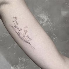 a small flower tattoo on the arm