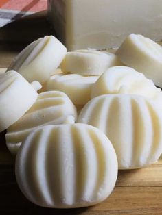 several pieces of soap sitting on top of a wooden cutting board