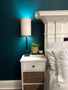 a nightstand with a basket on top of it next to a night stand and lamp