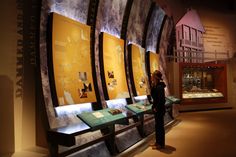 a woman standing in front of two display cases