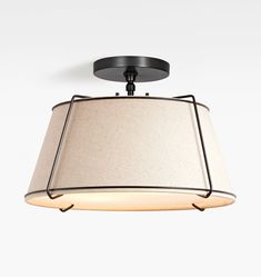 a light fixture with a beige shade on the top and black trimmings around it