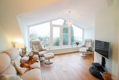 a living room filled with furniture and a flat screen tv on top of a hard wood floor