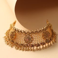 Description This glamorous yet simple choker set is designed for your festive days. The Yuthi classic choker from Tarinika is crafted with geometric filigree patterns with floral nakshi based on an antique gold tone with dangling metal balls & pearls. Whether it’s a wedding or a special event - this will be a perfect companion. Details & Specifications: Materials used: Brass Alloy with Antique Gold Plating Weight – Choker 99.71 gm, Earrings 38.33 gm Length – Choker 17.5 cm, Earrings 5 cm Make it Simple Choker, Filigree Pattern, Choker Set, Metal Ball, Gold Choker, Gold Plating, Special Event, Antique Gold, Special Events