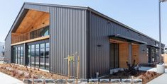 a building that is made out of metal and wood with lots of windows on the side