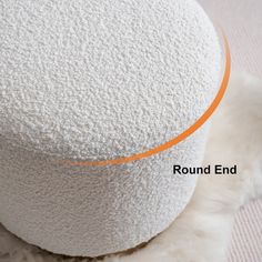 a round white ottoman with an orange line around the top and bottom part on it