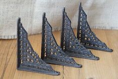 four cast iron sailboats on wooden floor next to burlock cloth wallpaper