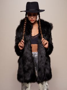 Women's Faux Fur Coat - Classic This Faux Fur Coat for Women in Black Wolf features an oversized hood with ears, gorgeous custom Wolf buttons, and cozy pockets. This shaggy faux fur is perfect for everyday wear or dressing up for a night out on the town. Black Wolf Characteristics LOYALTY – CONFIDENCE – WISDOMThe Black Wolf is a mystery with inner wisdom that reaches far beyond its years. This spirit has a gift for communication and can often be heard howling the music of the wild. A Black Wolf Winter Faux Fur Coat, Long Outerwear, Fur Coat Fashion, Demin Jacket, Womens Faux Fur Coat, Hooded Trench Coat, Leopard Print Coat, Fur Coats Women, Vegan Fashion