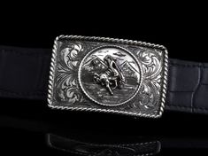 The Tyson R Bronc by Comstock Heritage is a hand crafted Sterling Silver trophy buckle with attention to detail. This buckle features a center piece of a bronc and rider (who's losing his hat in the ride) atop a hand engraved mountain scene, inside of a hand wrought small rope border. Surrounding the whole center scene is our classic Victorian engraving inside another, larger, Sterling rope edge. Measures approximately 1 3/4" x 2 5/8" Fits up to a 1.25" belt strap Victorian Engraving, Rope Border, Flask Bottle, Mountain Scene, Men Jewelry, Shot Glasses, Gift Accessories, Hand Engraving, Turquoise Stone