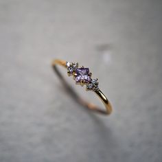 a gold ring with three stones on top and one stone in the middle, sitting on a surface