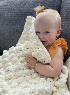 a baby wrapped in a crochet blanket