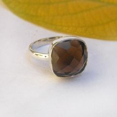 Material: 925 sterling silver Gemstone: Smoky quartz Birth Stone: April Stone Color: Brown Band Color: Silver/ Gold/ Rose Gold Stone Size: 12 mm Stone Shape: Cushion Stone Cut: Checkered Stone Authenticity: Natural Style: Statement Thanks for stopping by! Happy Shopping 🛍️ H O W ~ T O ~ O R D E R  It's easy as 1, 2, 3! 1. Select options from the dropdown menu  2. Add to cart and proceed to checkout. C A R E ~ T I P S We don't want your special moment to fade. To maintain the quality of your new Classic Smoky Quartz Jewelry As A Gift, Classic Smoky Quartz Jewelry As Gift, Faceted Sterling Silver Crystal Ring Gift, Brown Ring, Brown Rings, Birthday Gift Ring, Smoky Quartz Ring, Faceted Ring, Ring Cushion