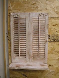 an old wooden window with shutters on the outside and inside, in front of a stone wall