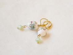 Dainty porcelain earrings are dainty and cute. In these gold plated earrings, I have paired a heart-shaped ceramic bead with a cute small light green freshwater pearl. The color combination is very elegant - the earrings look almost vintage but still modern at the same time. Handy lever-back closure that looks nice and makes sure you won't lose your earrings.   The height of the earrings 1.6 inches = 4 cm, including the ear wire. Each earring is made to order. Very pretty earrings, easy to wear on any occasion. Are you looking for other type of porcelain earrings? Here are a few options:  https://www.etsy.com/listing/1162478035/blue-porcelain-pearl-earrings-dainty https://www.etsy.com/listing/1185493197/green-porcelain-pearl-earrings-cute https://www.etsy.com/listing/1205650999/butterfly-p White Lever Back Earrings As Gift, White Lever Back Earrings For Gift, October Jewelry, Earrings Ceramic, Porcelain Earrings, Ceramic Heart, Freshwater Pearl Earrings, Back Drop, Baroque Pearl Necklace