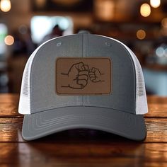 *Add some personality to your wardrobe with our leather patch hat design. *60% cotton/ 40% polyester, 100% polyester mesh backed trucker snapback cap, faux-leather laser engraved patch *Structured six-panel, mid-profile with pre-curved bill and adjustable plastic snapback closure *One size first most. Hat sizing: 7 - 7 3/4 inches, crown height approx 6 1/2 " *Faux-leather patches are engraved in the USA Casual Leather Trucker Hat With Logo Patch, Adjustable Trucker Hat With Leather Patch For Streetwear, Adjustable Leather Patch Trucker Hat For Streetwear, Leather Trucker Hat Snapback, Adjustable Trucker Hat With Leather Patch, Adjustable Leather Trucker Hat With Letter Patch, Leather Trucker Hat With Letter Patch And Flat Bill, Leather Trucker Hat With Letter Patch, Leather Patch Hat