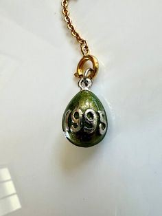 "Joan Rivers collectible 1995 green egg charm. The green egg has 1995 written in silver on the front and a ribbon of silver on the side. The attached spring ring is used to connect to other charms to make a necklace. The egg measures 1\" in length with attached gold chain with spring ring measuring 2\" in length. The widest part of the egg is 1/2\" wide. In very good condition." Green Pendant Charms For Gifts, Anniversary Green Nickel-free Necklace, Green Charms With Lobster Clasp For Gift, Green Charms Jewelry For Anniversary, Green Charm Necklace For Anniversary, Green Charm Necklaces For Anniversary, Nickel-free Green Charms For Gifts, Vintage Green Personalized Jewelry, Vintage Personalized Green Jewelry