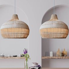 two wicker lamps hanging from the ceiling above a dining room table