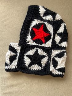 a black and white crocheted hat with a red star on it