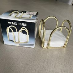 a box with some napkins in it next to a pair of gold metal clips