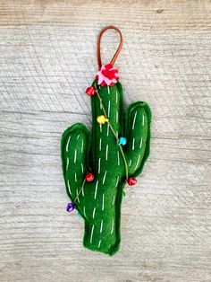 a green cactus ornament hanging on a wooden surface