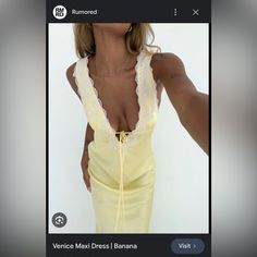 a woman in a yellow dress is taking a selfie with her cell phone while wearing a white lace top