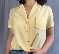 Vintage yellow polo blouse in great condition. There's a button missing on the bottom, but everything looks great otherwise. Luxury Yellow Short Sleeve Blouse, Yellow Summer Blouse With Pockets, Yellow Blouse With Pockets, Yellow Blouse With Pockets For Summer, Spring Yellow Tops With Pockets, Yellow Workwear Tops With Pockets, Yellow Work Shirt With Pockets, Yellow Collared Top With Button Closure, Classic Yellow Summer Blouse